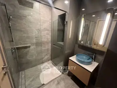 Modern bathroom with glass shower and stylish blue basin