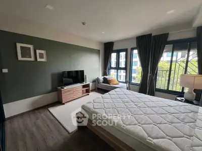 Spacious bedroom with modern decor and large windows offering a serene view, perfect for relaxation.