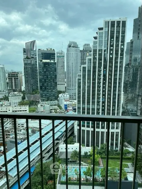 Stunning cityscape view from a high-rise balcony overlooking modern skyscrapers and lush greenery.