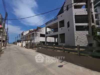 Street view of unfinished residential buildings under clear blue sky