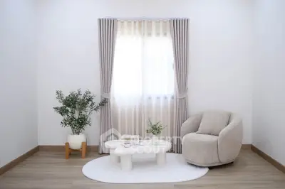 Minimalist living room with cozy armchair, elegant curtains, and stylish coffee table.