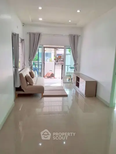 Bright living room with modern sofa and balcony view, perfect for relaxation.