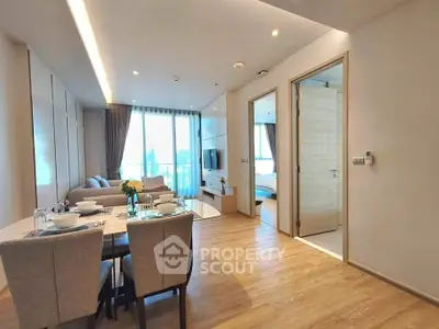 Modern open-plan living and dining area with wooden flooring and natural light.