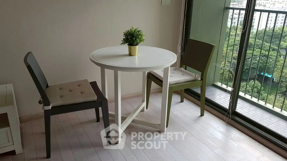 Cozy dining area with round table and chairs next to a large window with a scenic view.