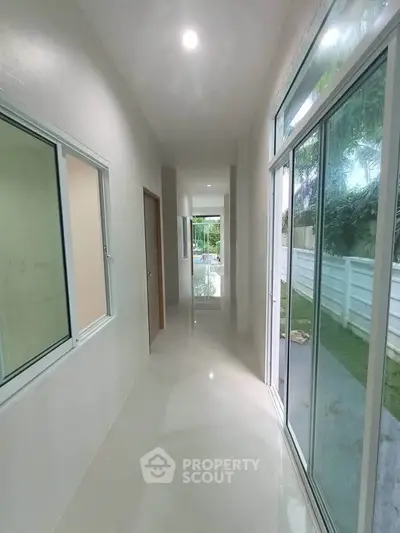 Bright hallway with large windows and garden view in modern home