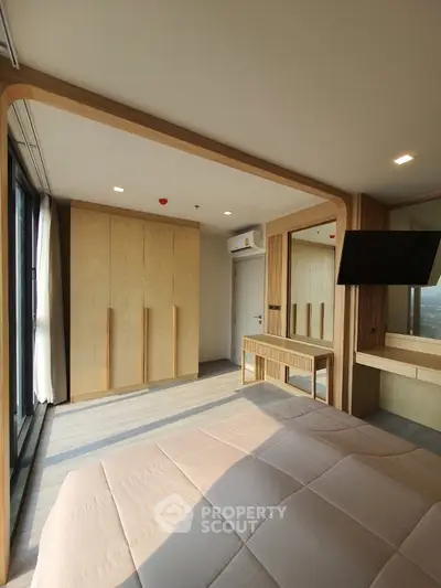 Spacious bedroom with large bed, wooden accents, and ample natural light, perfect for relaxation and comfort in a modern home.
