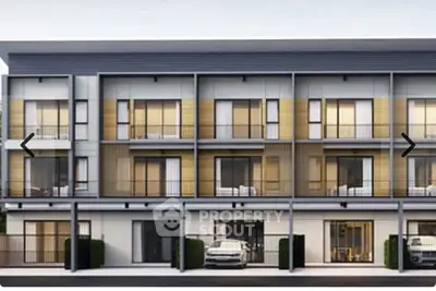 Modern multi-story residential building with large windows and balconies.