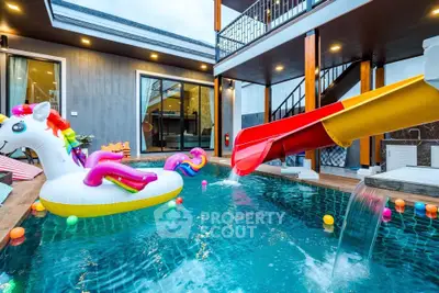 Luxurious pool area with slide and unicorn float, perfect for family fun and relaxation.