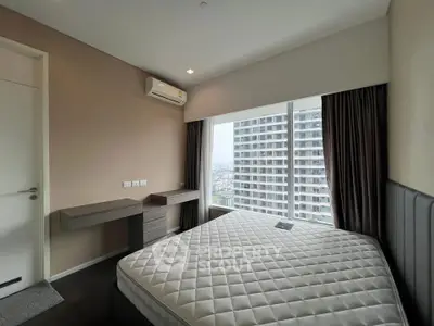 Modern bedroom with large window offering stunning city view in high-rise apartment.