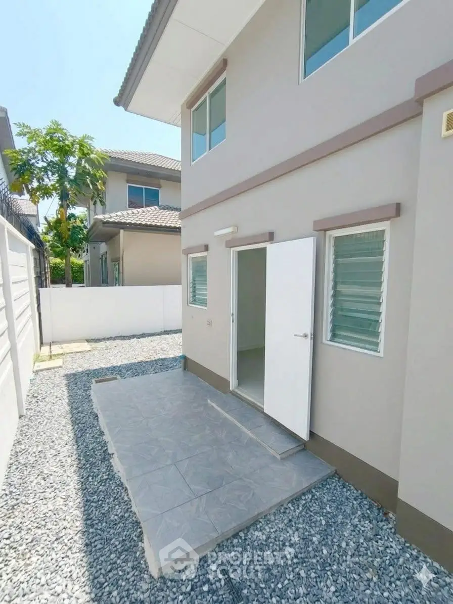 Modern two-story house exterior with clean design and spacious backyard area.