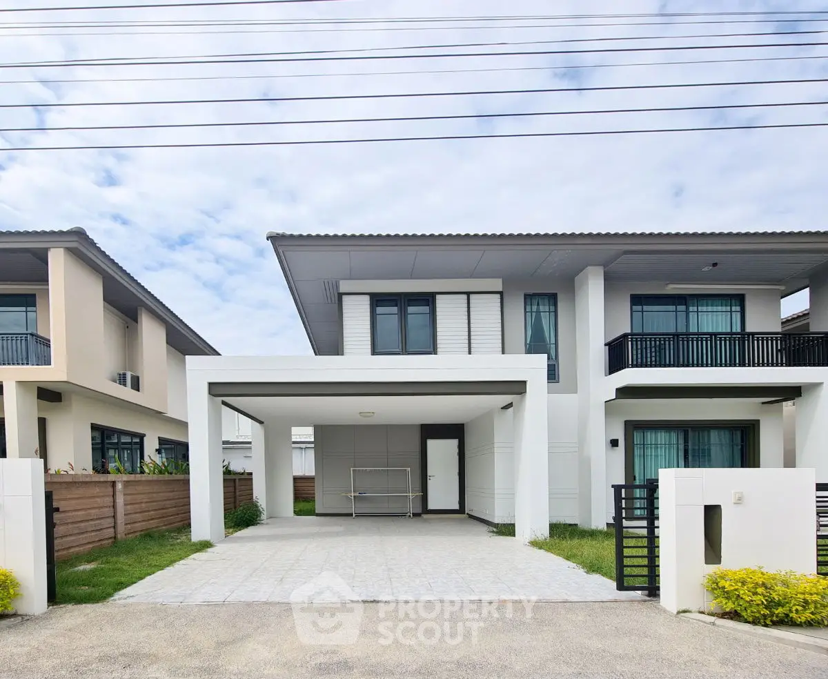 Modern two-story house with spacious driveway and sleek design in a suburban neighborhood.