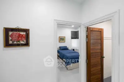 Cozy bedroom with blue bedding and adjacent bathroom in modern home.
