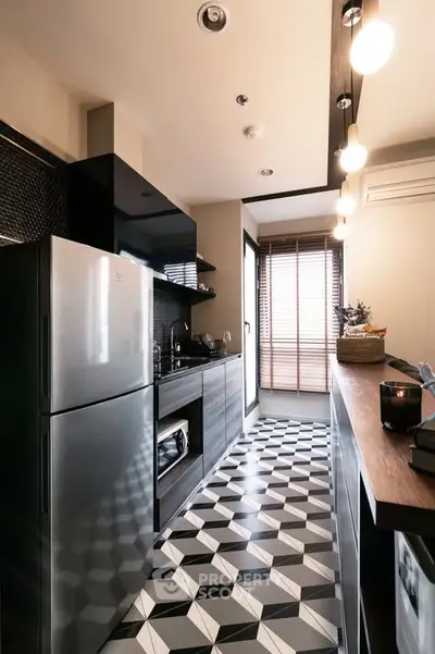 Modern kitchen with sleek design, featuring geometric floor tiles and stainless steel appliances.