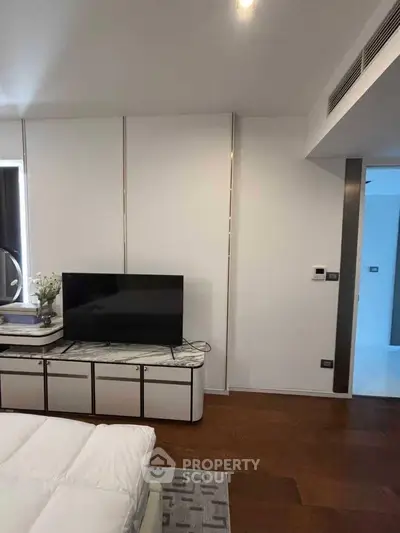Modern bedroom with sleek TV stand and cozy decor