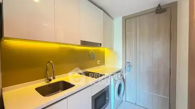 Modern compact kitchen with sleek white cabinets, built-in appliances, and stylish lighting.