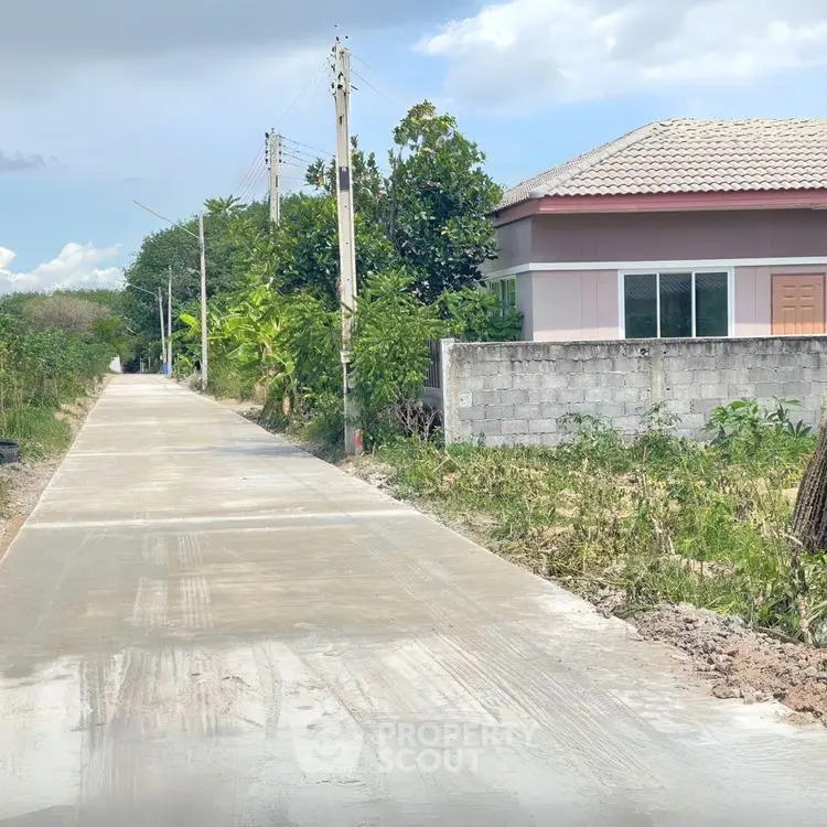 Charming suburban house with a newly paved driveway and lush greenery.