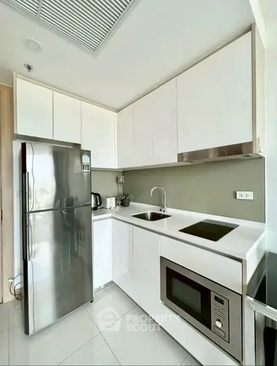 Modern kitchen with sleek white cabinets and stainless steel appliances