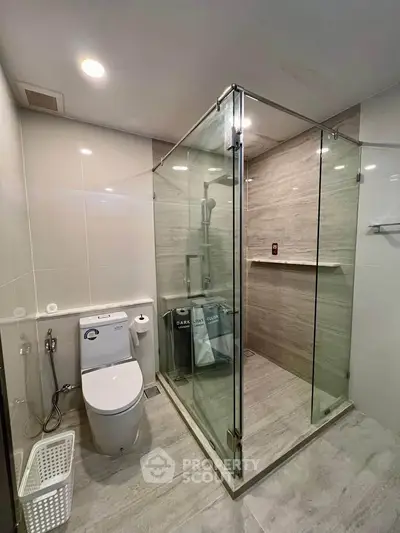 Modern bathroom with glass shower enclosure and sleek fixtures