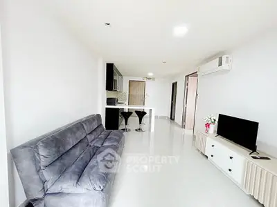 Modern living room with sleek furniture and open kitchen layout in a bright apartment.