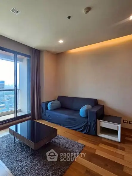 Modern living room with city view and cozy sofa in high-rise apartment.