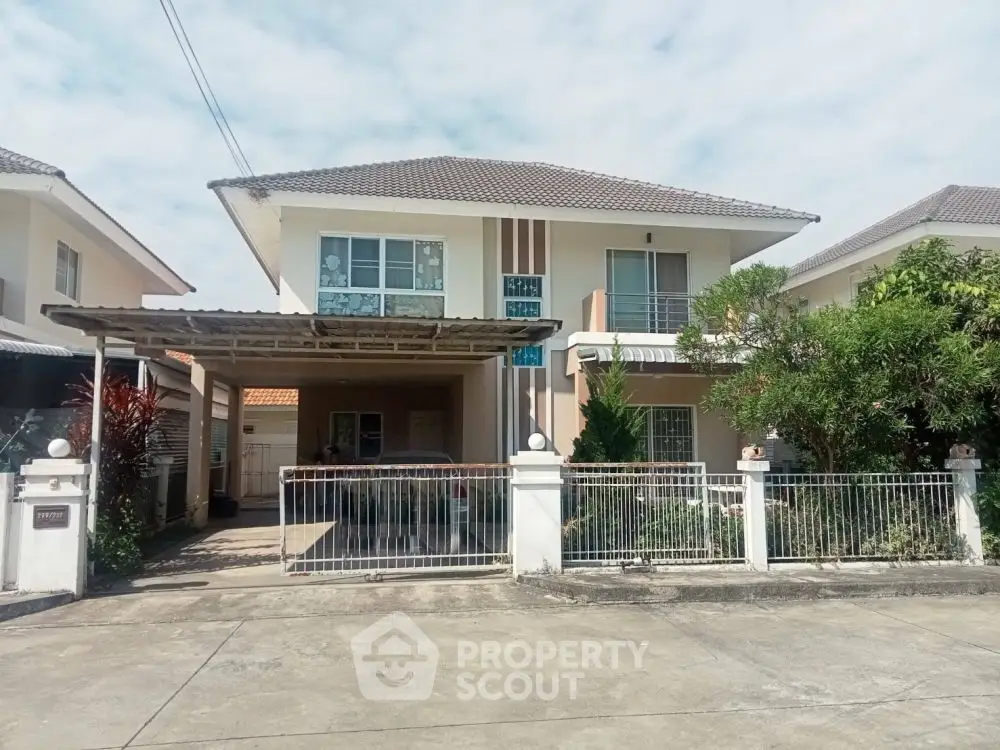 Charming two-story house with spacious driveway and lush greenery, perfect for family living.