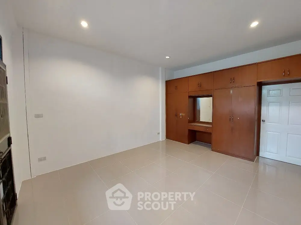 Spacious and bright kitchen with modern appliances, ample cabinetry, and sleek white tiles, perfect for culinary enthusiasts.