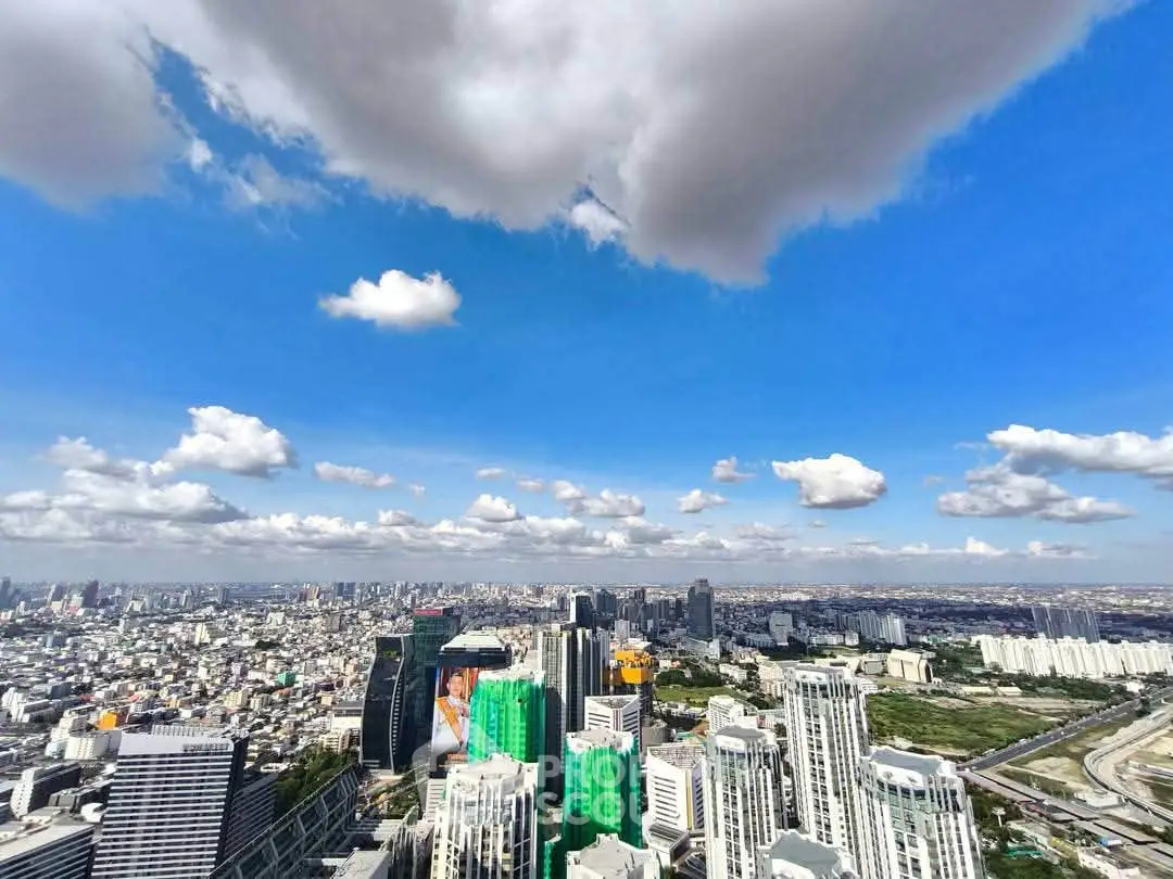 Stunning cityscape view from a high-rise building showcasing urban skyline and expansive blue sky.