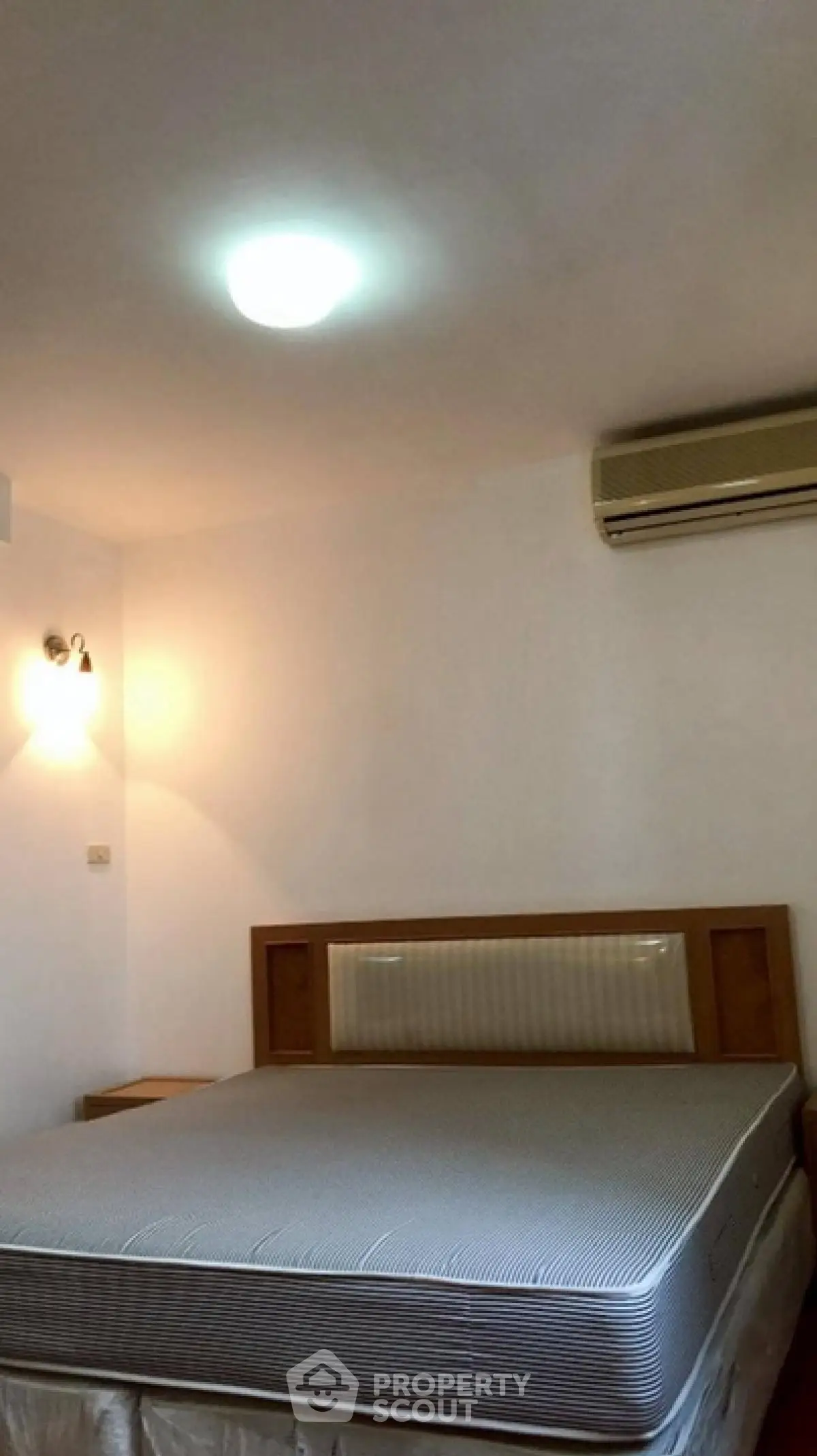 Cozy bedroom with modern lighting and air conditioning unit.