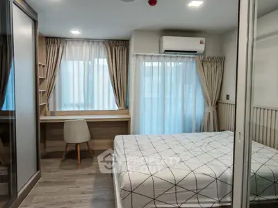 Modern bedroom with large windows and stylish decor, featuring a cozy workspace and elegant curtains.