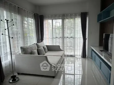 Modern living room with elegant gray sofa and large windows