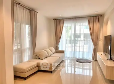 Spacious living room with elegant curtains and modern furniture, perfect for relaxation and entertainment.