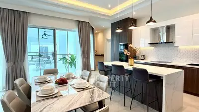 Luxurious modern kitchen with marble island and dining area, featuring elegant lighting and open balcony view.