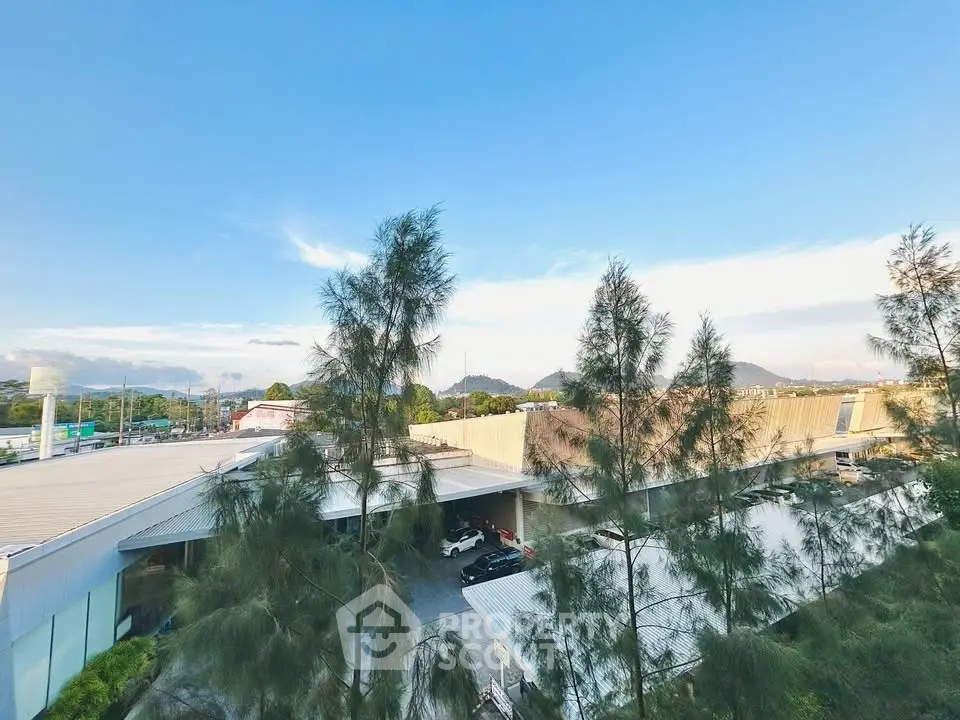Stunning panoramic view from a high-rise building showcasing urban landscape and distant mountains.