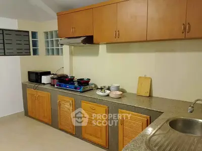 Spacious kitchen with wooden cabinets and modern appliances in a cozy home.
