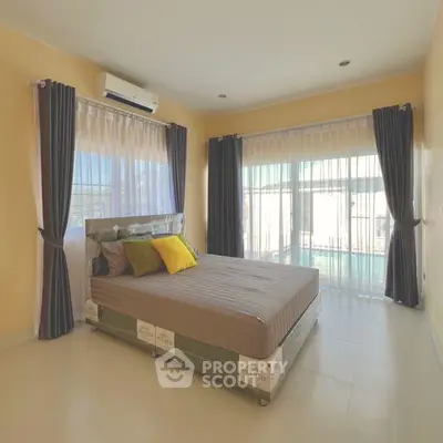 Spacious bedroom with large windows and modern decor