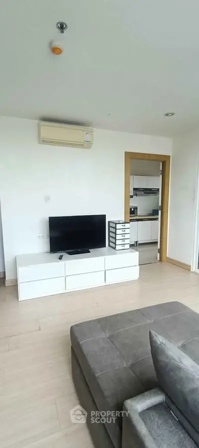 Modern living room with sleek TV unit and air conditioning in a stylish apartment.