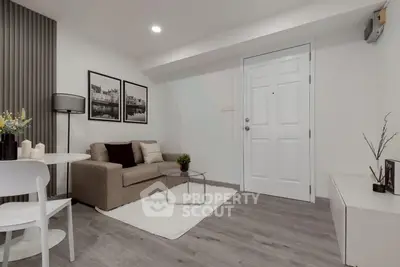 Modern living room with cozy sofa, stylish decor, and elegant flooring in a contemporary apartment.