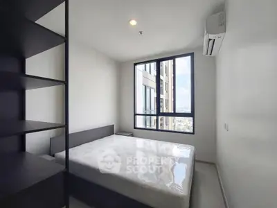 Modern bedroom with large window and city view in high-rise apartment