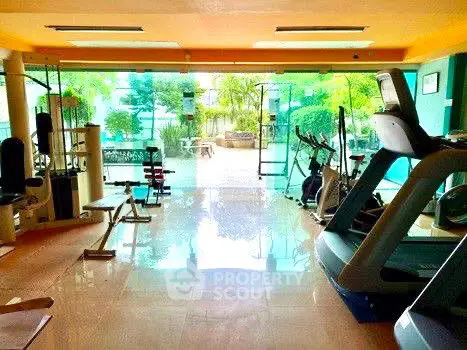 Spacious gym with modern equipment and garden view in luxury property.