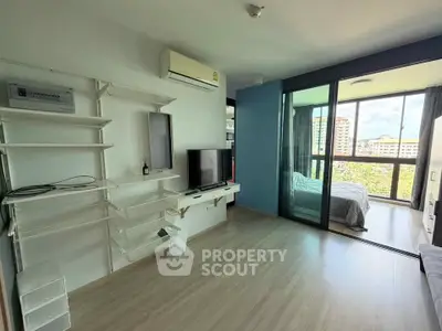 Modern apartment interior with open living room and bedroom, featuring large windows and sleek design.