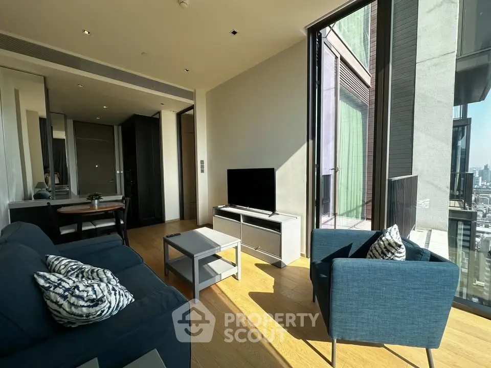 Modern living room with floor-to-ceiling windows and stylish furniture in a high-rise apartment.