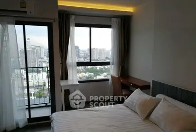 Modern bedroom with city view and balcony access in high-rise apartment