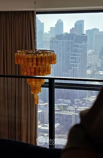 Luxurious high-rise apartment with stunning city view and elegant chandelier.