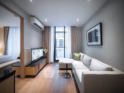 Modern living room with sleek furniture and large window in a stylish apartment.