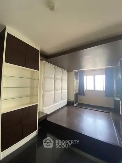 Modern bedroom with built-in shelving and large window for natural light