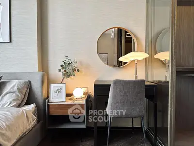 Stylish bedroom with modern decor and elegant lighting, featuring a cozy workspace and chic furnishings.