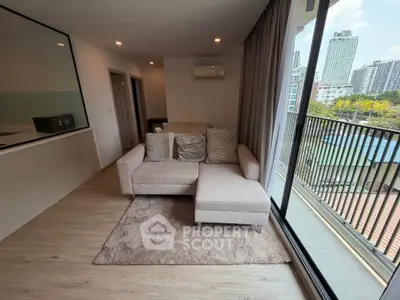Modern living room with cozy sofa and city view balcony in high-rise apartment.