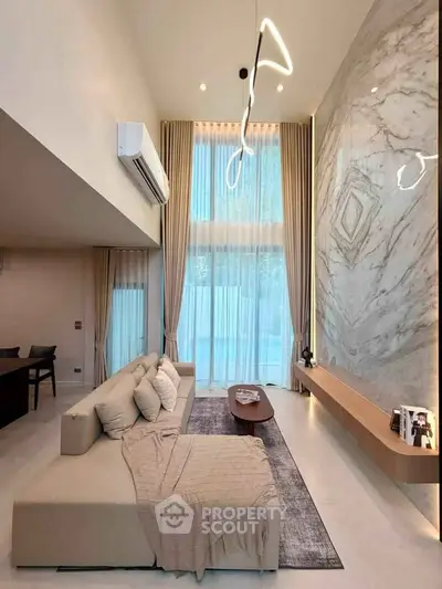 Luxurious modern living room with high ceilings and elegant marble wall