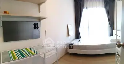 Bright and airy bedroom with modern furnishings and large window for natural light.