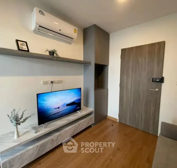 Modern living room with sleek design, featuring air conditioning and stylish TV setup.